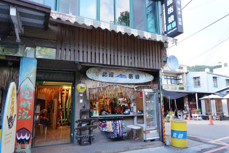 北堤衝浪俱樂部店面在街上轉角的小店面，裡面陳列很多衝浪板及販售沙灘衣褲