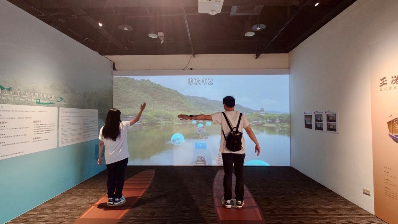 民眾透過「勇闖宜蘭河」沉浸式互動設施，在模擬划行鴨母船的趣味競技中，親身體驗昔日宜蘭河的水路運輸情境。