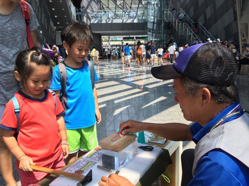 志工協助漢本特展教育推廣敲打銅片關卡活動照片